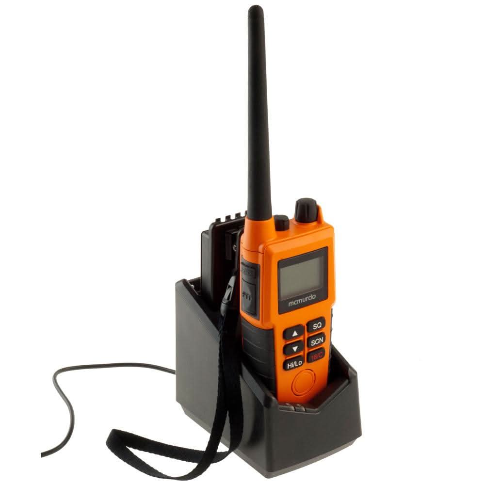 McMurdo R5 GMDSS VHF handheld radio in charging dock with orange casing and black strap