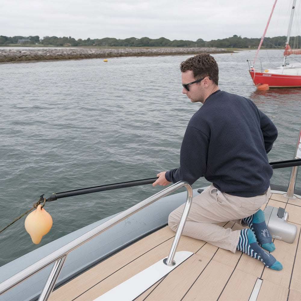Man using Revolve Rollable Boat Hook on boat to retrieve buoy in water